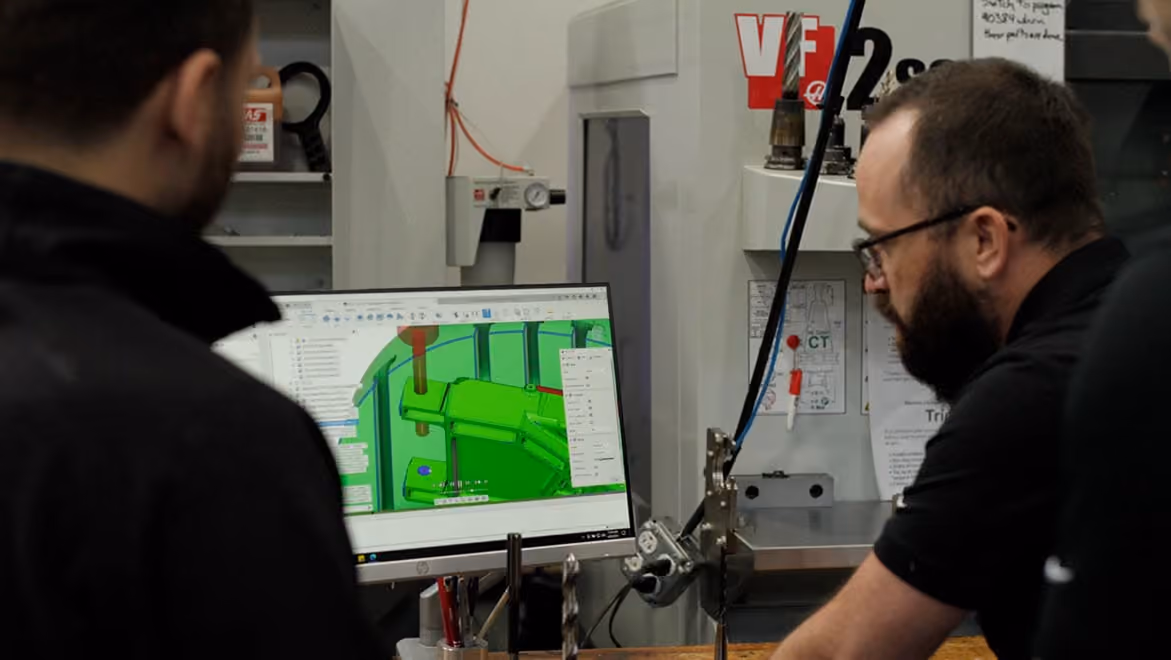 Profesionales revisando un modelo CAD/CAM en un taller de mecanizado