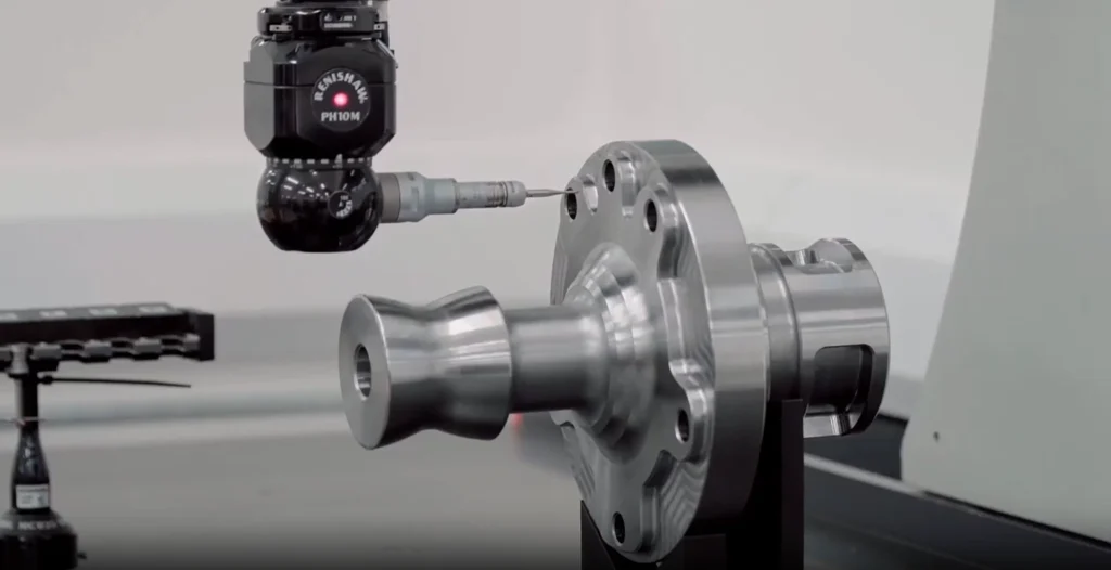 Palpador de una máquina CMM inspeccionando una pieza metálica