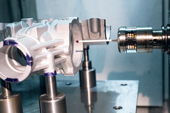 Palpador de una sonda Renishaw OMP60 en contacto con una pieza mecanizada