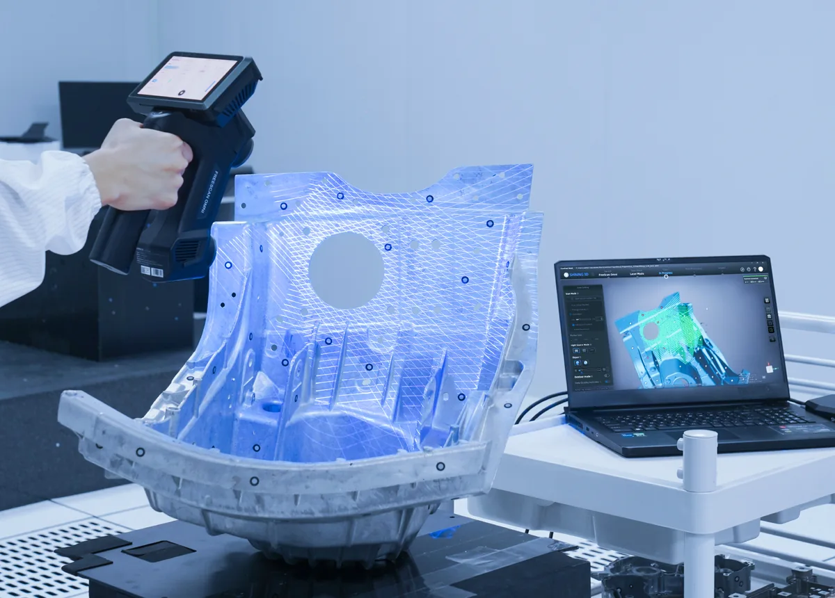FreeScan Omni escaneando un componente industrial junto a una estación de trabajo