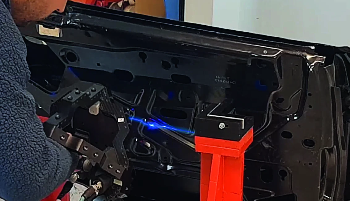 Operador utilizando M-Scan 120 sobre un panel automotriz con línea láser azul