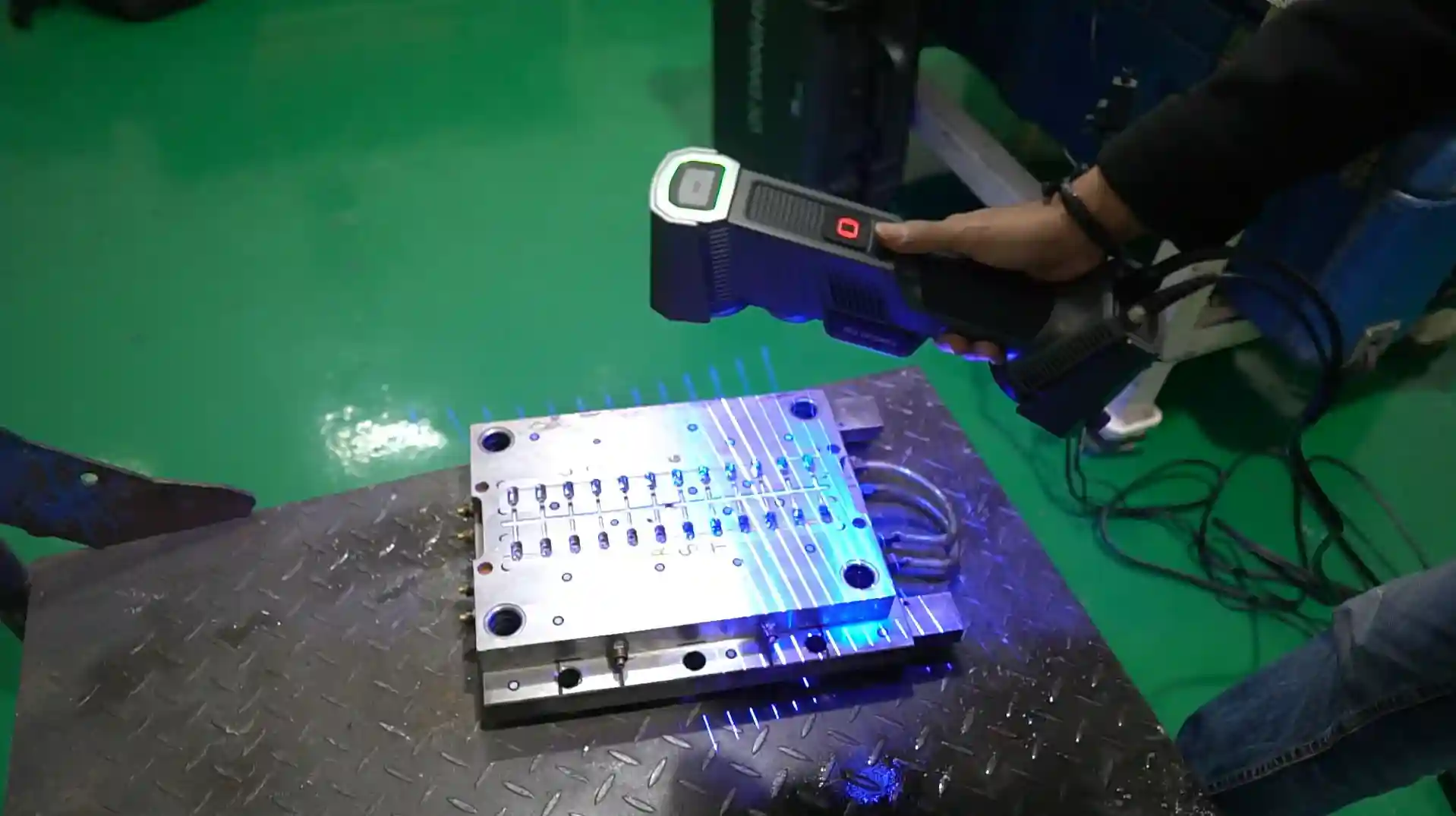 FreeScan Trio proyectando líneas láser sobre una pieza metálica para capturar su superficie