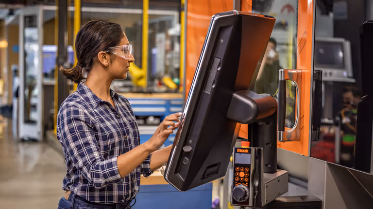 Operadora utilizando el control de una máquina CNC