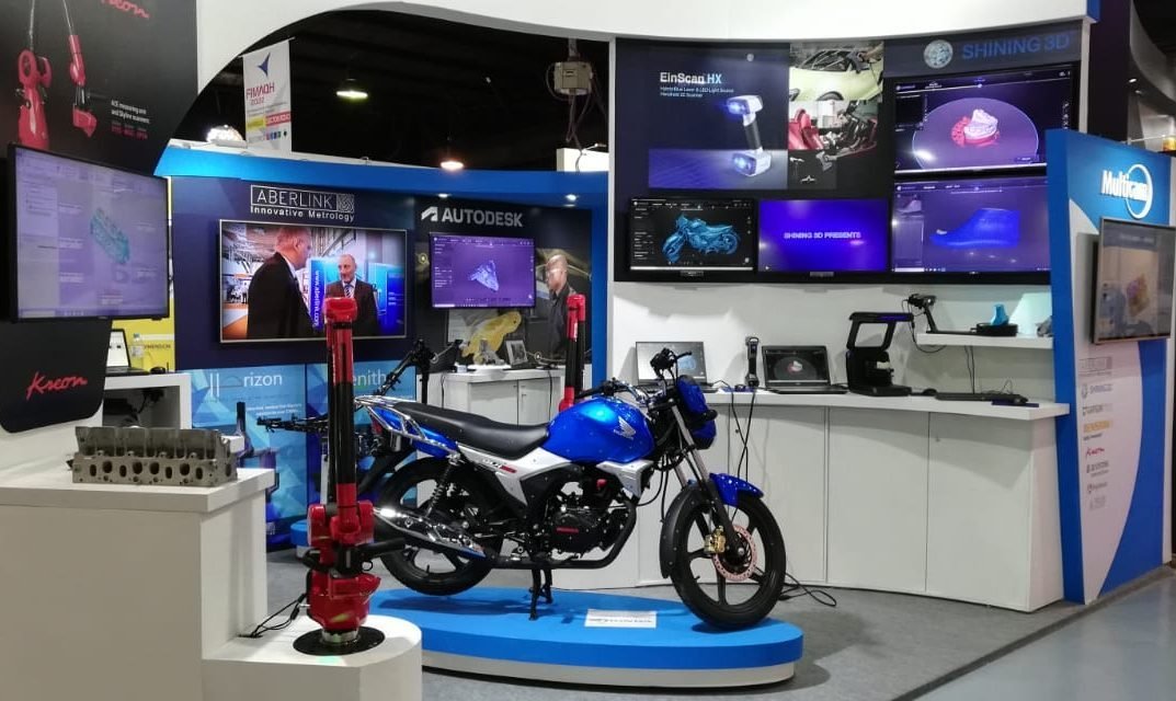 Otra vista del stand de MultiCAM en FIMAQH, con equipos y pantallas de software.